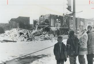 Ice-sheathed ruins are all that remain of four stores and 10 offices above them, destroyed Saturday in a $700,000 blaze that swept part of central bus(...)