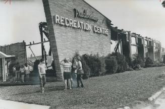Fire sweeps a swimming pool. Spectators survey the wreckage after the second major fire in five years at Prudhomme s Garden Centre, in Vineland, Ont.,(...)