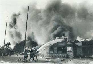 Firehoses battle vainly against the blaze sweeping the Tam O'Shanter Golf, Curling and Skating Club in Scarborough yesterday