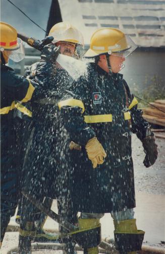 A firefighter gets hosed down by colleagues after battling a lumber yard fire - and 30c (86F) temperatures - in Markham yesterday. Four units were nee(...)