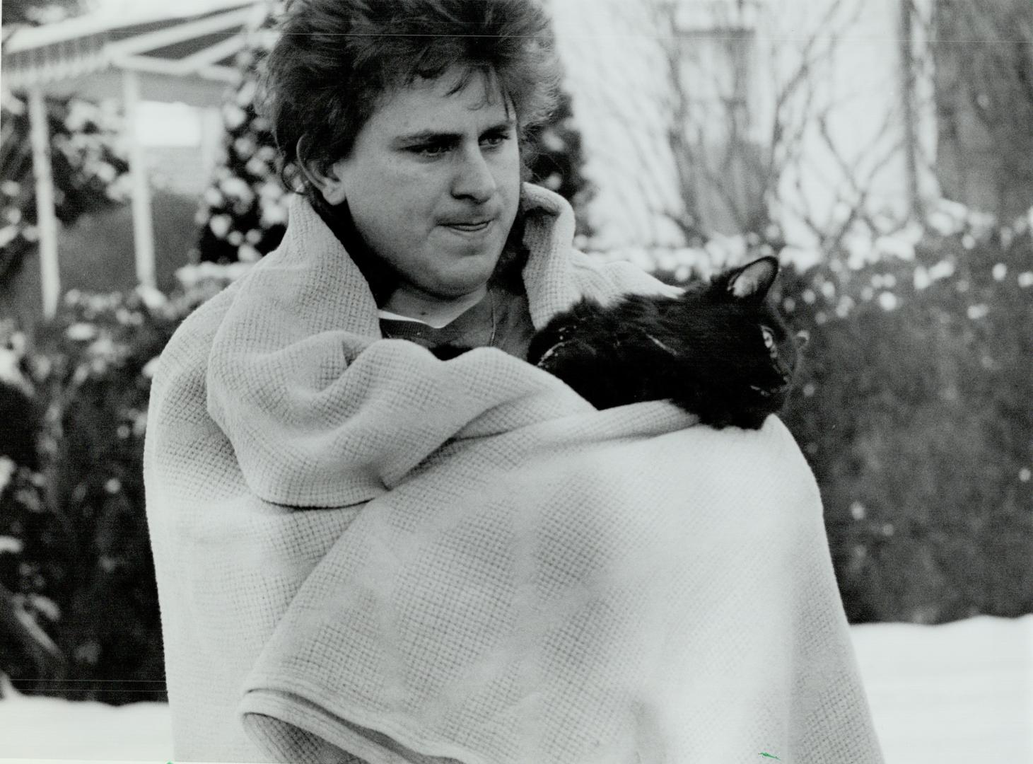 Rescued: North York tenant Mark Vicari and his cat Dylan were rescued by firefighters Monday after a fire started in the basement of their house