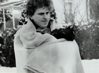 Rescued: North York tenant Mark Vicari and his cat Dylan were rescued by firefighters Monday after a fire started in the basement of their house