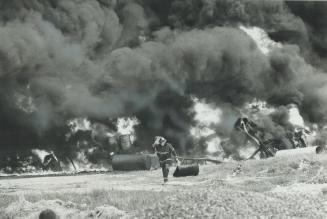 A fireman runs from exploding drums of chemical solvents in the multi-million-dollar fire yesterday at the Ashland Oil Canada plant in York Borough in(...)