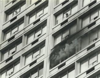 Resident gasps for air as smoke billows out of window below in the fatal fire at Plaza II hotel and apartment complex today
