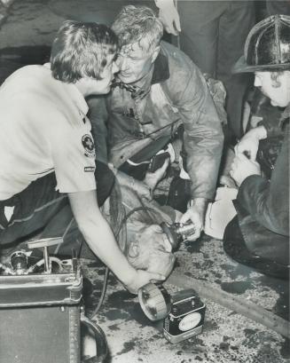 Firemen give roomer oxygen. Toronto firefighters give oxygen to elderly roomer they found in smoke-filled Jarvis St. house last night. The unidentifie(...)