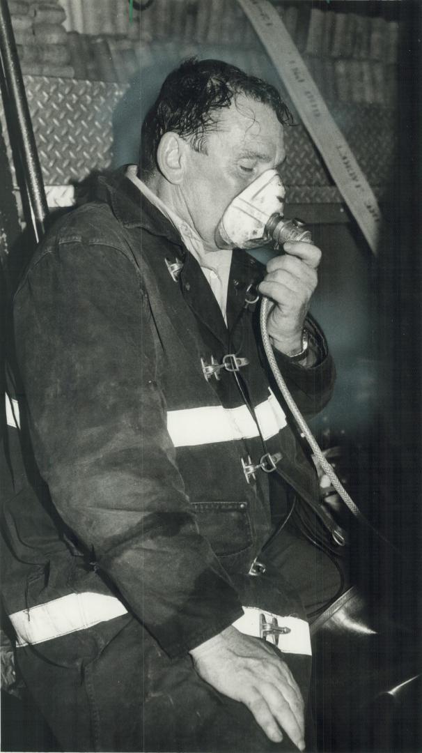 Arsonist s victims: Fire captain James Coles, left, breathes oxygen after being overcome by smoke while fighting fires set by an arsonist at the Harbour Castle Hilton last night