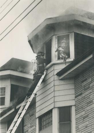 One firefighter (right) takes a breather as another climbs ladder to relieve him