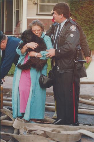 Tears of relief. Eleanor Maloff, 51, carries her dog, Bare, as Metro police Constable Bill Guthrie leads her away from a house fire on Leslie St. Eigh(...)