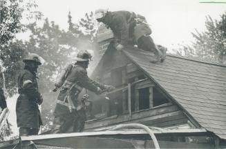 Fighting to save roof. Crews work on the burning roof of a two-storey home on Balfour Ave. at Danforth Ave. and Main St. yesterday. Fire officials are(...)