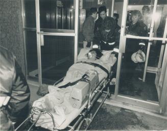 Fire victim taken to hospital, A woman is removed from a Parliament St