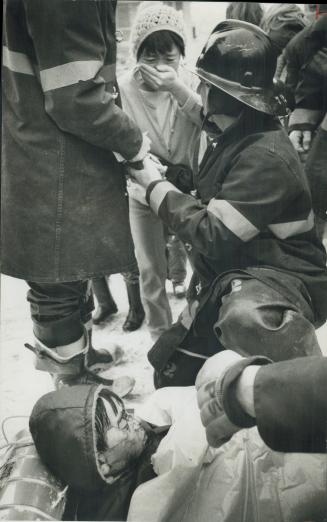 His head cut in a collison with another toboggan, 8-year-old Kun-Il Chung is comforted by firemen and his mother, Dong-Sun Chung of Thorncliffe Park D(...)