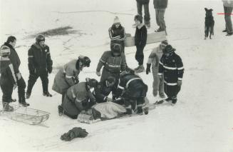 Ambulance attendants and firefighters help Jeff Johnson after he was injured on toboggan in Scarborough