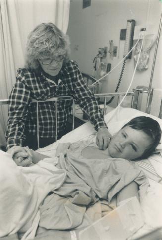 Sewer casualty: Kristin Gataveckas, 9, hurt in a storm sewer, is comforted by his mother while awaiting surgery