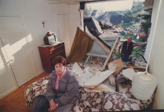 Bulldozer's wake: Cathie McBride sits in disbelief yesterday in what remains of her Etobicoke bedroom while her husband, Gene, looks in from the outside