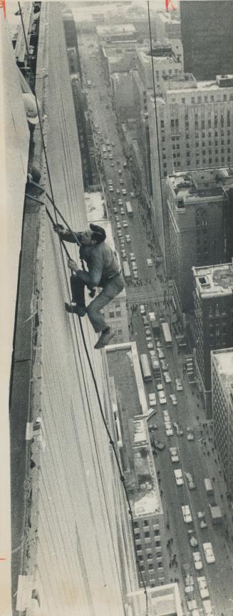 Rescuer Harry Harrison climbs back to top of Simpson's Tower after being lowered to cradle where he tied ropes around waists of two trapped window cleaners