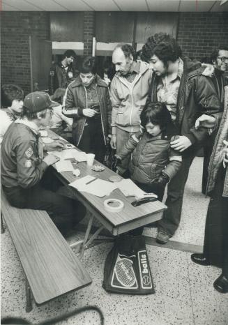 A Mississauga family registers at the evacuation centre in Brampton Centennial Secondary School (upper right)