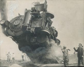 The fireman of this locomotive, one of the largest in use by the Pennsylvania Railroad, was killed and the huge engine was left in this precarious pos(...)