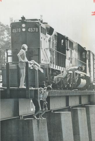 Last-second leap as a freight train roars down is the object of boys aged 10 to 15 who play a deadly game of chicken on a railway trestle north of Mal(...)
