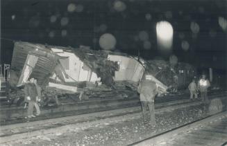Train derails in west end. CP Rail workers police wait for a crane to lift a boxcar, part of a freight train that derailed after being sideswiped by a(...)