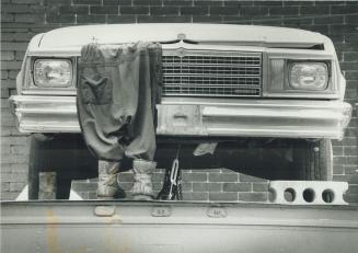 Caught up in his work. It looks as though a Toronto mechanic got into a tight squeeze under the hood. Actually, it's just a dummy set up by Bill Beits(...)