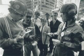 Construction workers Rodney Wood, left, and Mark Sullivan were skeptical yesterday when Tom Cruise lookalike handed out gold coins at King and Bay Sts(...)