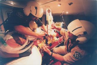 No time to lose: Critical-care flight paramedics Patrick Auger, left, and Kervin Madigan work on a patient inside the helicopter ambulance Bandage 1