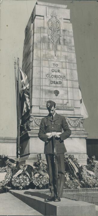 Airman from the R.C.A.F. bows his head in front of the Cenotaph while silent tribute is paid to those who died