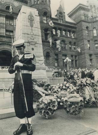 Head bowed over his reversed weapon, a seaman from HMCS York stands guard over the wreaths piled before Toronto's Cenotaph in front of the old city ha(...)