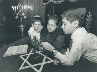 The Feast of Lights. Preparing to mark the eight days of Chanukah are Gideon bielak, 8, left, Anna-Rachel Krakowsky, 10, and Kenny Fishman, 11, lighti(...)