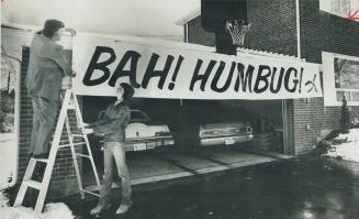 Mack Smith and son Jeffrey, 15, erect a different kind of Christmas greeting over their Canfield Pl