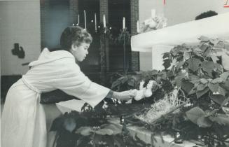 Away in a manager. The Christ-child is palced in a manger by Oakville altar boy Jimmy Henry, 10, during midnight mas s at St. James Roman Catholic Chu(...)