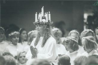 Yuletide ritual. Christina Gemfors, wearing a crown of candles symbolizing the saint of lights, takes part in the Lucia Festival during the Swedish Ch(...)