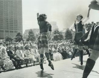 Three young girls perform the Highland Fling in front of an audience that includes Prime Minist…