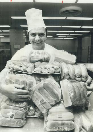 Five-cent hot dogs at Queen's park party for Canada Day are the specialty of pastry chef Louis Combaluzier