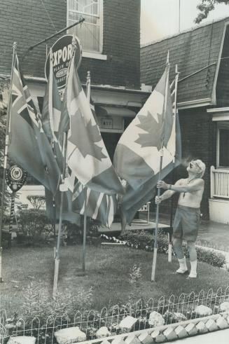 Lindsay Calow, 72, flies two Canadian flags and a Union Jack outside his home and barbershop on Sammon Ave