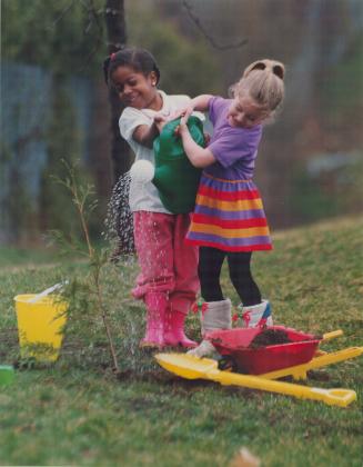 Danielle Leamy, left, and Natalie Parkinson, both 4, junior kindergarten pupils from Dallington Elementary School, North York, celebrated Earth Day last week by dousing a freshly planted tree