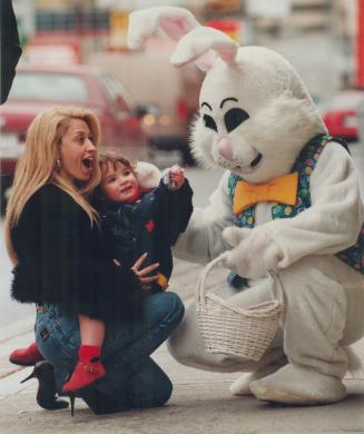 Maria Arich and Austyn Wunsche, 2, get some chocolate from the Easter Bunny at a Mount Pleasant Rd