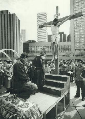 Solemn service: Kevin McKiney portrays Christ o ing a peace vigil held outside Toronto City Hall yesterday ice drew about 1,200 who condemned man's inhumanity [Incomplete]