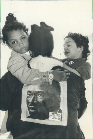 Honoring King: Moe Callaghan holds Thandi-We, 4, left, and Quicy Rafiki, 2, as Metro blacks pay tribute to Martin Luther King at Harbourfront yesterday