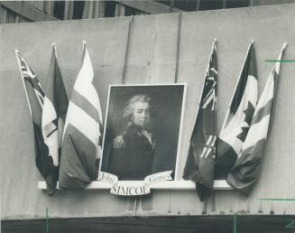 Familiar face: This portrait of John Graves Simcoe, the first governor of Upper Canada, looks down from outside city hall on the revellers at Nathan Phillips Square yesterday