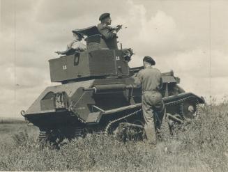 A tank crew halts its heavily armored vehicle at the top of a hill near Camp Borden to observe enemy locations