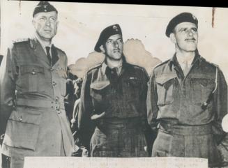 Leaders of Canadian troops in the Kiska task force watch transports being loaded with equipment and supplies at a Canadian port for the attack. Left t(...)
