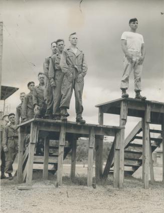 This picture shows the Canuck paratroopers on the special jumping platform receiving instructions from an American instructor on the proper methods of(...)