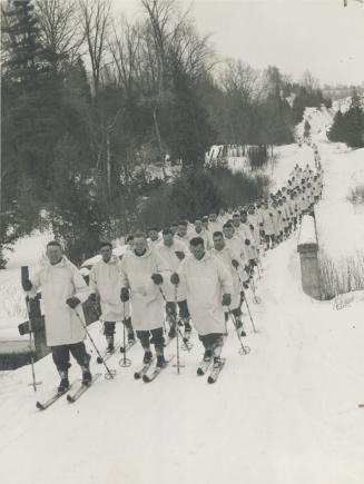 Cross country on skis march the Canadian Grenadier Guards during winter manoeuvres at Glenn Cross