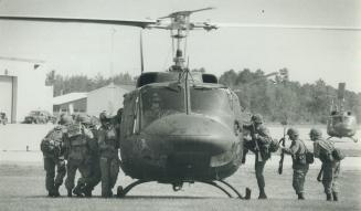 All aboard: Militia and regular troops practise clambering aboard a helicopter during manoeuvres at Canadian Forces Base Petawawa