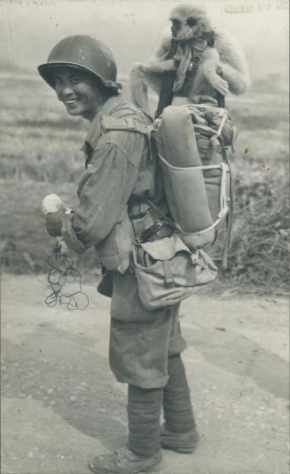 A monkey who likes travel hitchhikes on the knapsack of a Chinese infantryman on the new Ledo road that helped win Burma