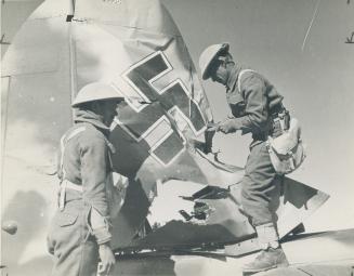 A souvenir for the folks back home in India is being clipped out of the tail of a German dive-bomber by these Rajput troops, on service with the Eight(...)