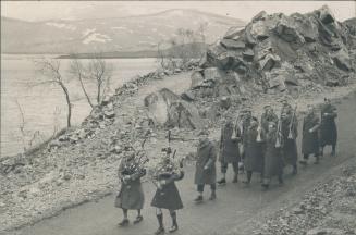 Headed by their pipers, some of the Guardsmen are seen marching along a loch-side road (right) on their way to take up new positions