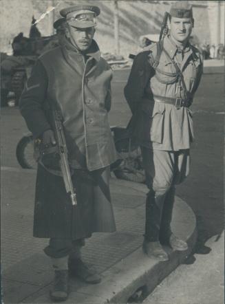 British and Italian police, each with his tommy gun, patrol the streets of Tripoli together