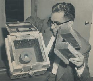 C. Wilfred Bridgeford with wooden box for Capsule. Radio-active material sits in round lead castle inside